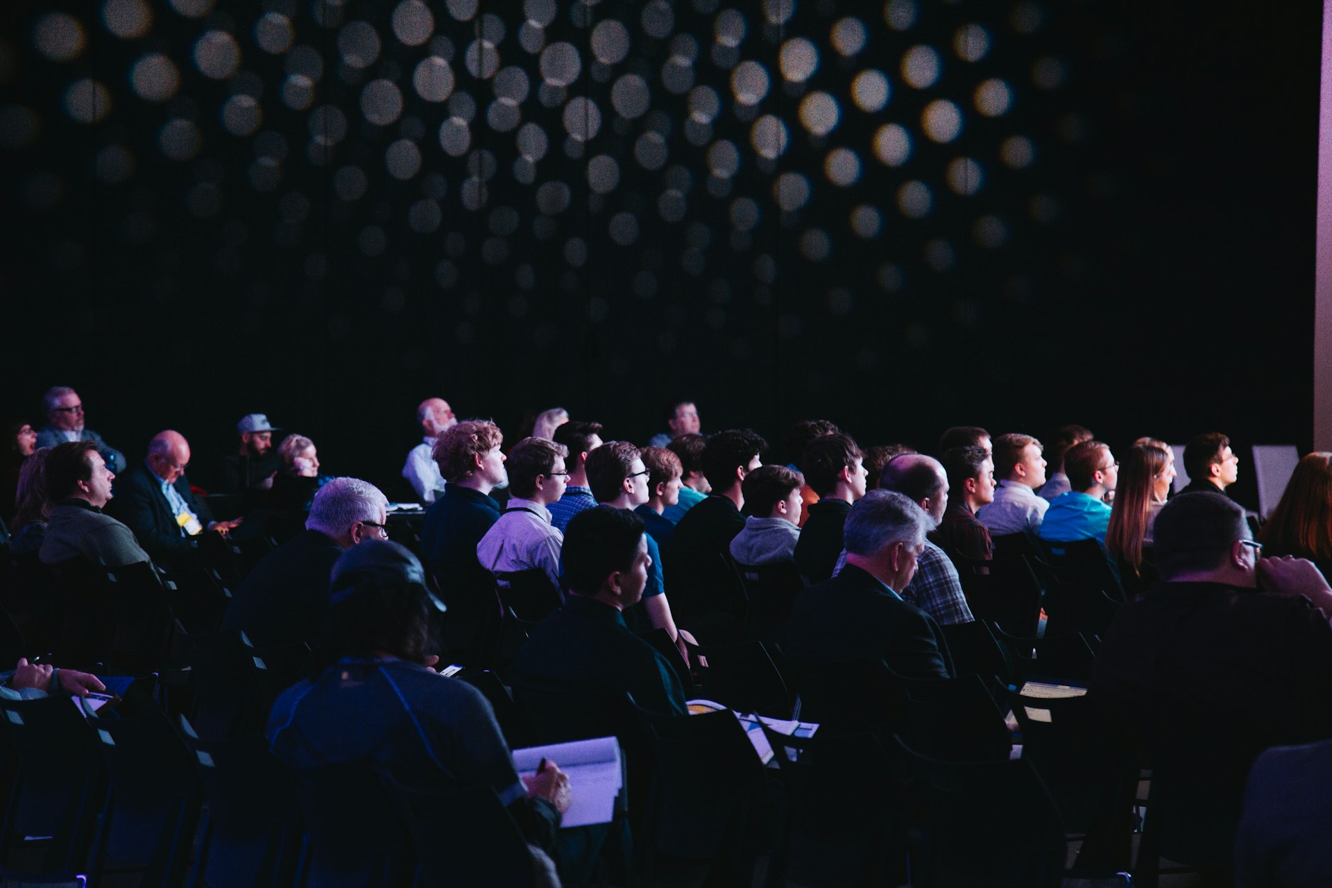 A speaker presenting to a full conference hall