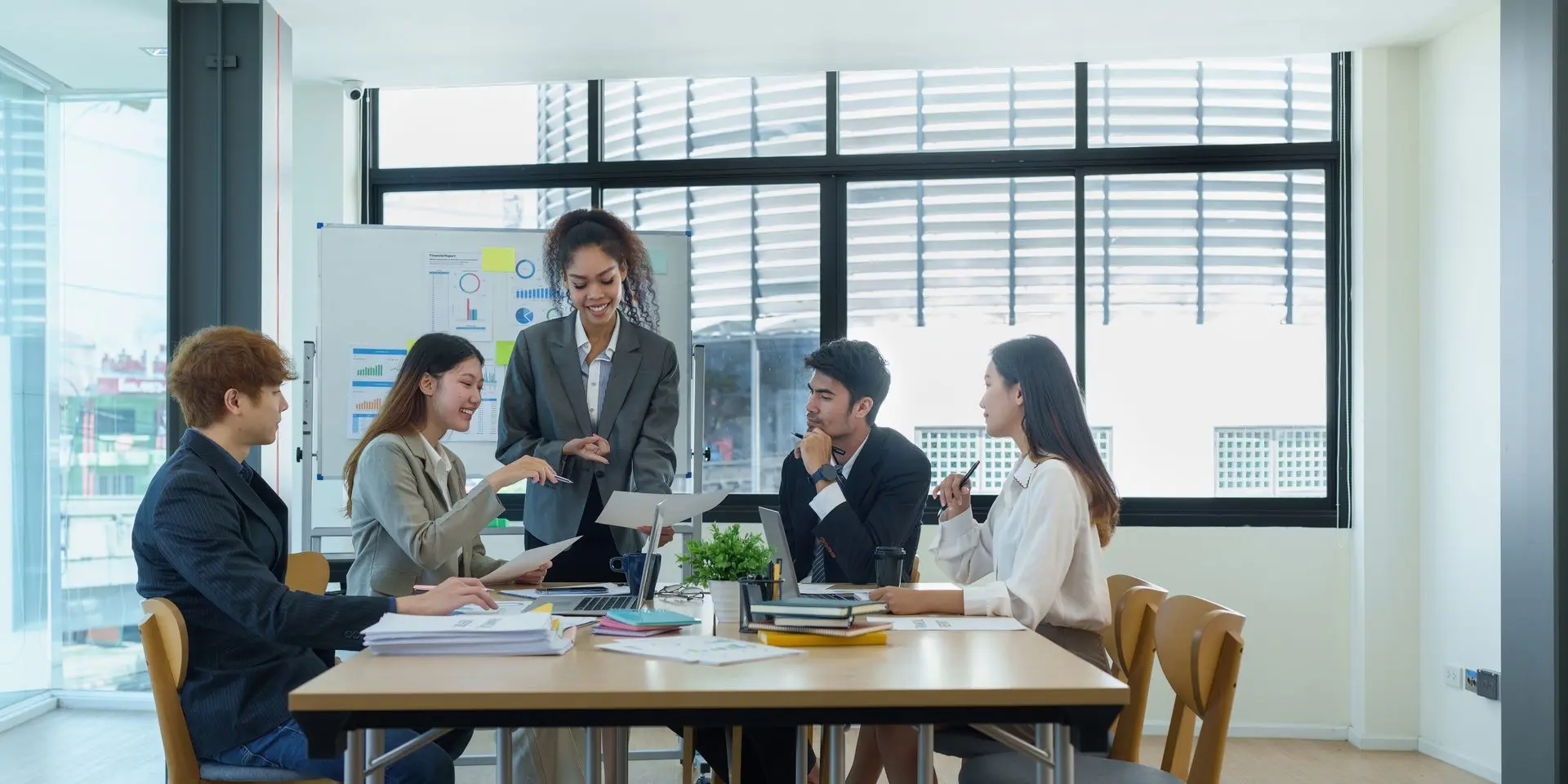 A leader presenting to an engaged team in a bright meeting room